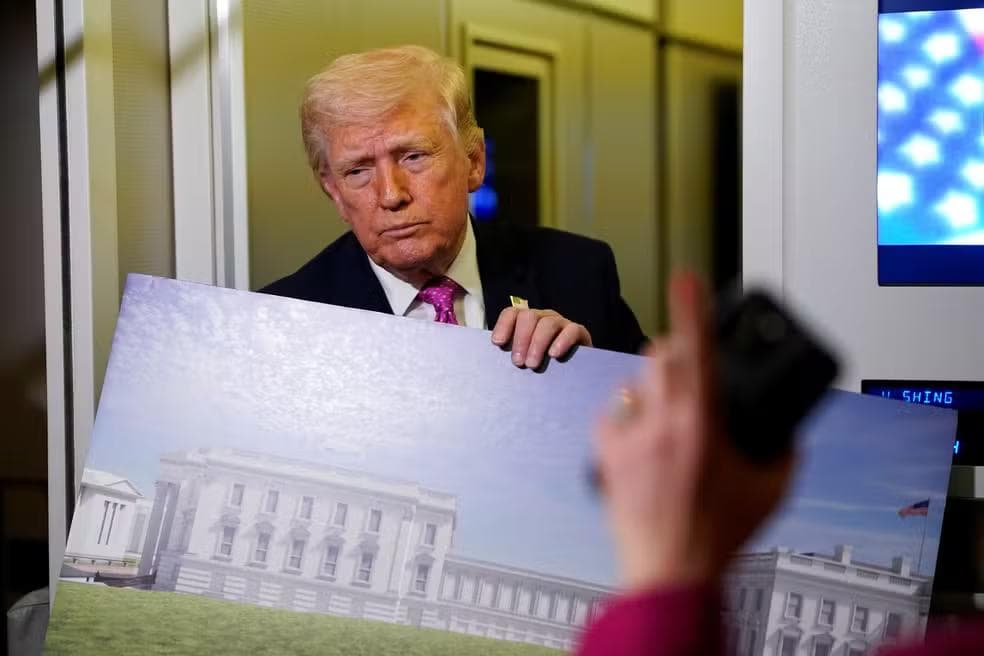 Donald Trump mostra imagens do projeto do salão de baile da Casa Branca, a bordo do Força Aérea Um, em 29 de março de 2026 — Foto: Elizabeth Frantz/Reuters