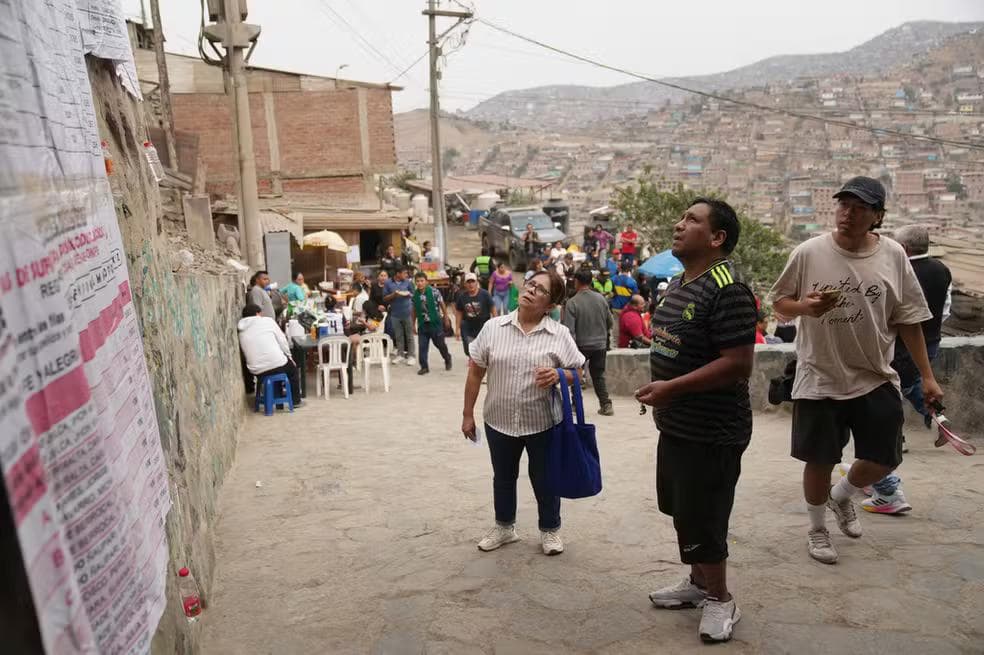Eleitores consultam lista na porta de seção eleitoral em Lima, no Peru, durante o segundo turno das eleições presidenciais no país, em 7 de junho de 2026. — Foto: Rodrigo Abd/ Reuters