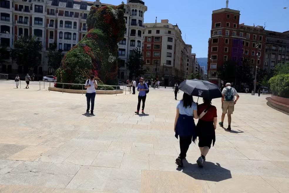 Pessoas se protegem do sol com guarda-chuvas durante uma onda de calor na primavera em Bilbao, Espanha , em 28 de maio de 2026 — Foto: REUTERS/Vincent West