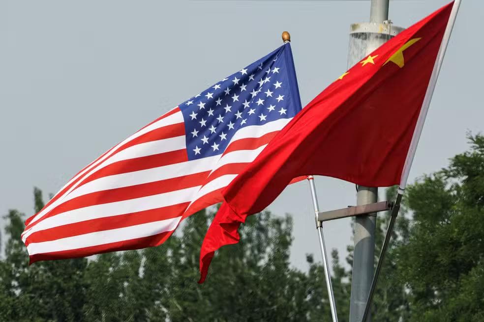 Bandeiras da China e dos Estados Unidos em uma rua chinesa antes da visita de Donald Trump ao país, em 13 de maio de 2026 — Foto: REUTERS/Tingshu Wang