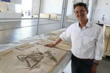 Professor Allysson Pinheiro ao lado do fóssil do dinossauro Ubirajara Estácio Jr./Gov. do Ceará